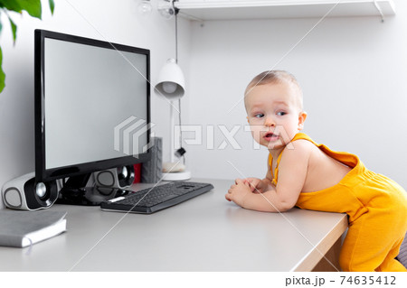 Caucasian funny little baby boy exploring computer, monitor and keyboard Caucasian funny little baby boy exploring computer, monitor and keyboard 74635412