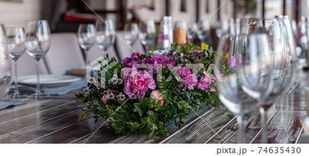 Modern veranda restaurant interior, flowers, banquet setting, glasses, plates Modern veranda restaurant interior, flowers, banquet setting, glasses, plates 74635430
