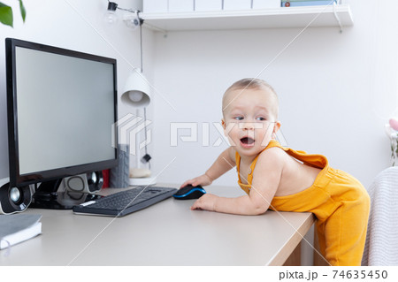 Caucasian funny little baby boy exploring computer, monitor and keyboard Caucasian funny little baby boy exploring computer, monitor and keyboard 74635450