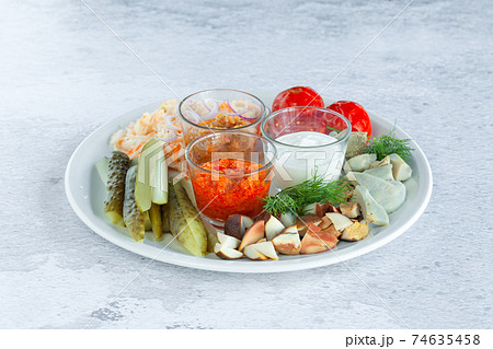 Assortment plate of pickled vegetables, chopped marinated mushrooms, cucumbers, tomatoes 74635458