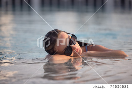 Beautiful women relaxing at the luxury poolside. Girl at travel spa resort pool. Summer luxury vacation. 74636681