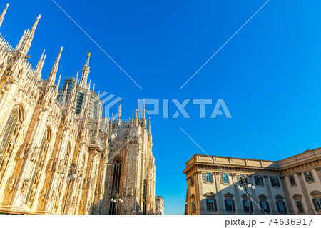 Famous church Milan Cathedral Duomo di Milano with Gothic spires and white marble statues. Top tourist attraction on piazza in Milan Lombardia Italy. Wide angle view of old Gothic architecture and art Famous church Milan Cathedral Duomo di Milano with Gothic spires and white marble statues. Top tourist attraction on piazza in Milan Lombardia Italy. Wide angle view of old Gothic architecture and art 74636917