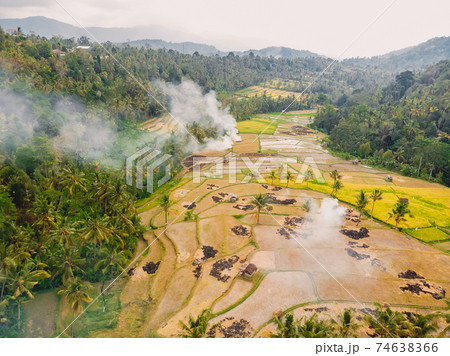 Aerial view with rice terraces and smoke. Rice fields in Bali island. Aerial view with rice terraces and smoke. Rice fields in Bali island. 74638366
