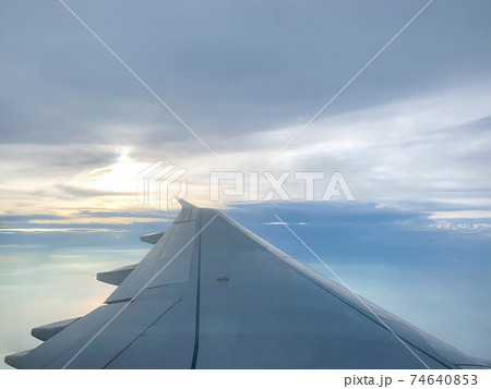 Wing of an airplane flying above in the evening Wing of an airplane flying above in the evening 74640853