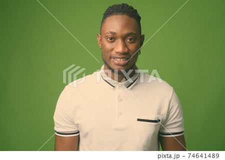 Young handsome African man from Kenya against green background Young handsome African man from Kenya against green background 74641489