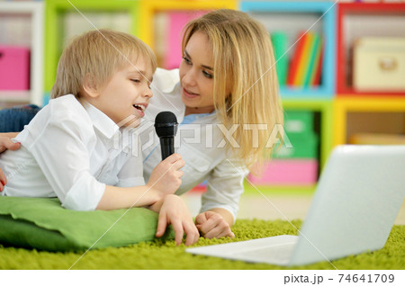 Portrait of mother and son singing karaoke together 74641709