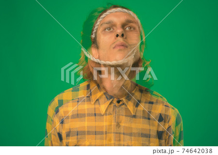 Studio shot of rebellious young man against green background 74642038
