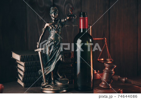 Bottle with wine and lady of justice, alcohol and crimes concept 74644086
