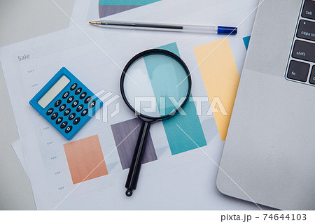 Accounting calculator, charts and magnifying glass. Business and finance concept Accounting calculator, charts and magnifying glass. Business and finance concept 74644103