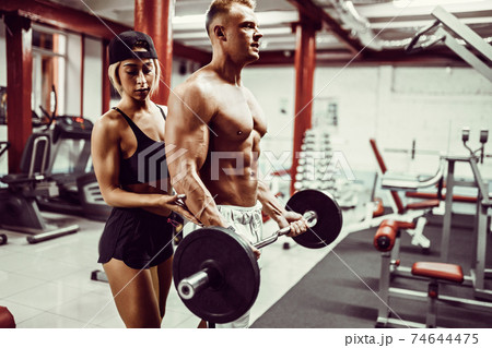 Young man and a woman team training with dumbbells 74644475