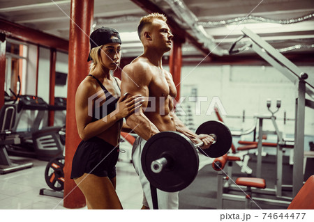Young man and a woman team training with dumbbells Young man and a woman team training with dumbbells 74644477