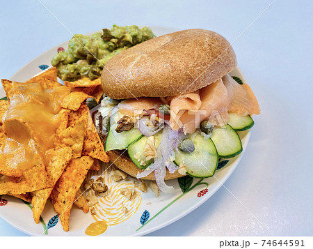 ベーグルサンドからはみ出すスモークサーモンのシズルカット 74644591