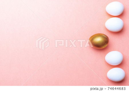 Easter background. Golden, white colour egg on pastel pink background in Happy Easter decoration. Spring holiday top view concept. Easter background. Golden, white colour egg on pastel pink background in Happy Easter decoration. Spring holiday top view concept. 74644683