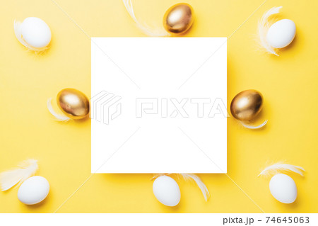 Easter pattern. Golden, white colour egg on pastel yellow background in Happy Easter decoration. Spring holiday top view concept. 74645063
