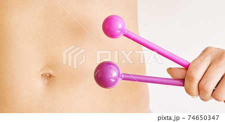 Young woman hand holding femine toys. Kegel adult exercise. Intimate gymnastics 74650347