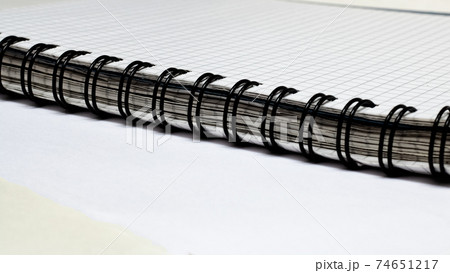 Black binding of thick notebook on white table Black binding of thick notebook on white table 74651217