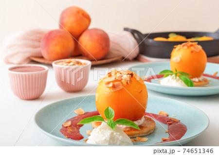 Roasted Peaches, tasty fresh fruit dessert with lemon, lime and basil creme fraiche and raspberry coulis. 74651346