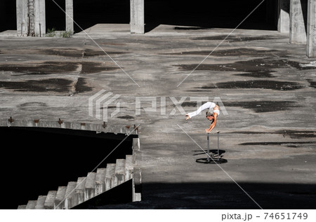 Flexible and fit girl standing on her hands keeping balance in the abandoned building. Concept of effort, self-development and healthy lifestyle  74651749