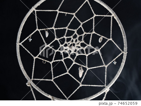 Mystical attribute dreamcatcher on a black background with smoke Mystical attribute dreamcatcher on a black background with smoke 74652059