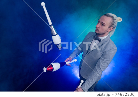 Man wearing formal suit juggling with clubs. Management, control and success Man wearing formal suit juggling with clubs. Management, control and success 74652536