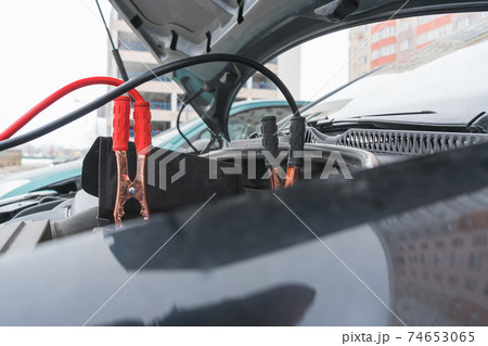 Jump cables on car low power battery. 74653065