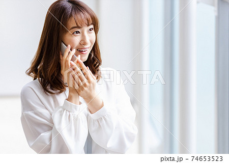 スマホを耳に当て微笑む女性 74653523