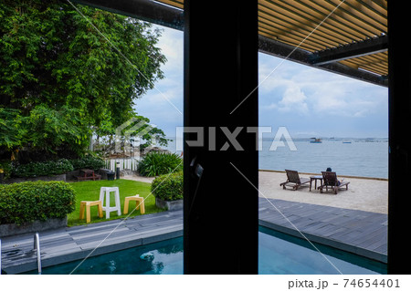 The view from the glass room overlooks the swimming pool, garden, chairs and the vast sea The view from the glass room overlooks the swimming pool, garden, chairs and the vast sea 74654401