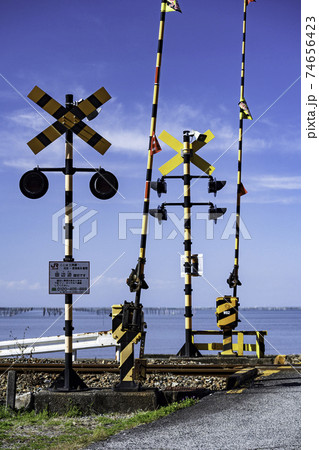 晴天の青空に白い雲有明海の青い海が見える三角線の踏切風景 晴天の青空に白い雲有明海の青い海が見える三角線の踏切風景 74656423