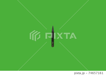 Black used pencil isolated on a green background Black used pencil isolated on a green background 74657161