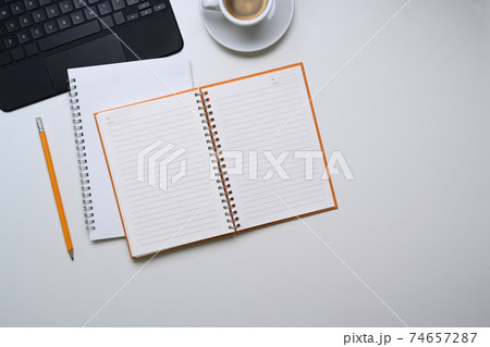 Above view of empty notebook, pencil, coffee cup and copy space on white background. 74657287