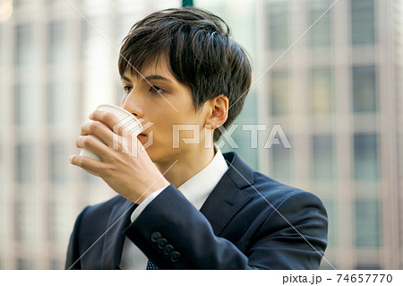 コンビニコーヒーを飲むビジネスマン コンビニコーヒーを飲むビジネスマン 74657770
