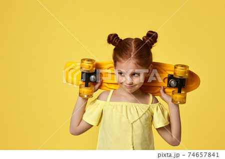 little child girl with yellow skateboard 74657841