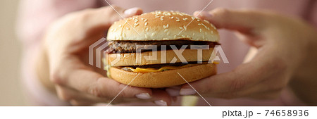 Female hands hold hamburger close-up 74658936
