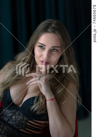 若い白人女性モデルが人差し指を唇に当てているポーズ 横視線の写真素材