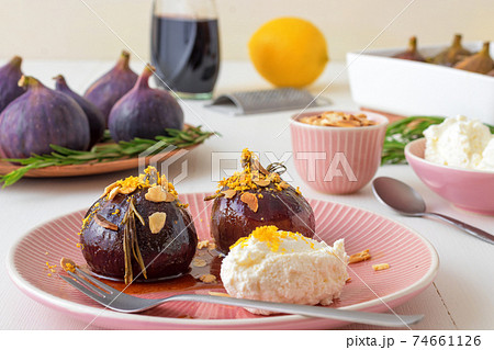 Caramelised figs with balsamic vinegar, rosemary, almonds and cottage cheese. Slow roasted homemade fruit dessert. White wooden table background. No people. Gordon Ramsey recipe. 74661126