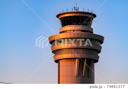 羽田空港夕日を浴びて赤い管制塔の写真素材