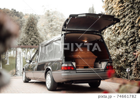 wooden coffin in the back of a car at the crematory 74661782
