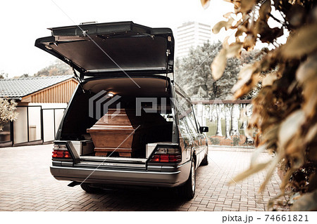 wooden coffin in the back of a car at the crematory 74661821