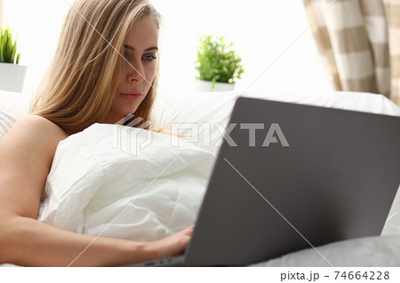 woman work winh laptop stay in bed early morning 74664228