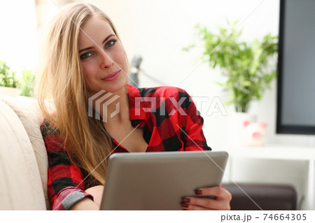 young woman surfing the internet hold tablet in arms search information 74664305
