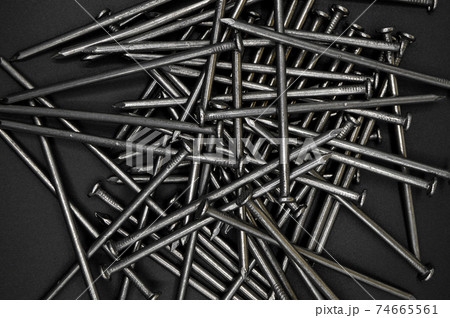 Pile of construction iron nails on a black isolated background Pile of construction iron nails on a black isolated background 74665561