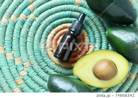 Top view of oil and slice of avocado on wooden table Top view of oil and slice of avocado on wooden table 74668342