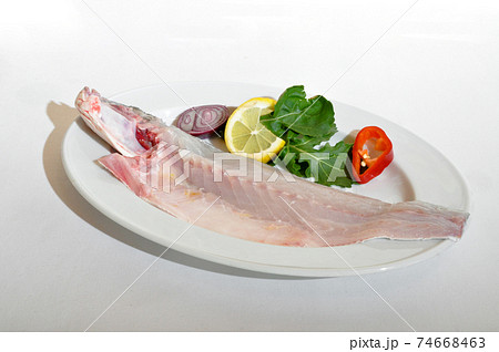 Mackerel fish cut in half in a plate, isolated on white background Mackerel fish cut in half in a plate, isolated on white background 74668463