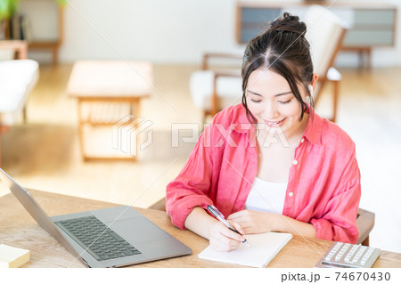 リビングでテレワーク中の若い女性 74670430