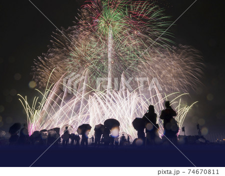 夜空に高くあがる花火 花火 雨の日の写真素材