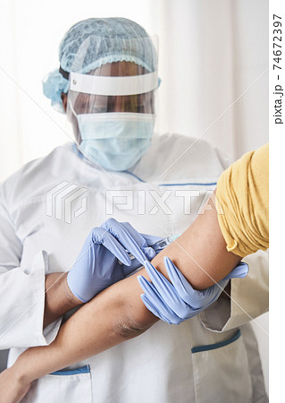 Nurse doing vaccination with serious expression 74672397