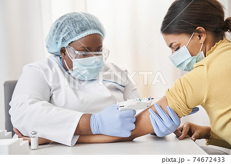 Nurse making injection for brunette female Nurse making injection for brunette female 74672433