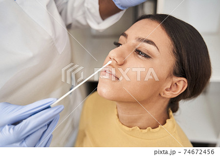 Worker with protective equipment performs coronavirus swab 74672456