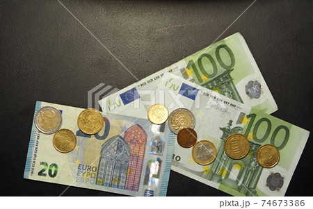 The euro banknotes and coins with copy space on the black background.	 74673386