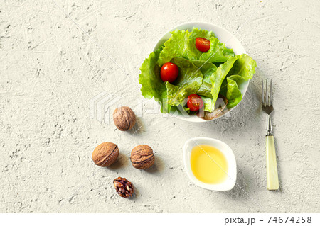 Salad and a bowl of walnut oil Salad and a bowl of walnut oil 74674258